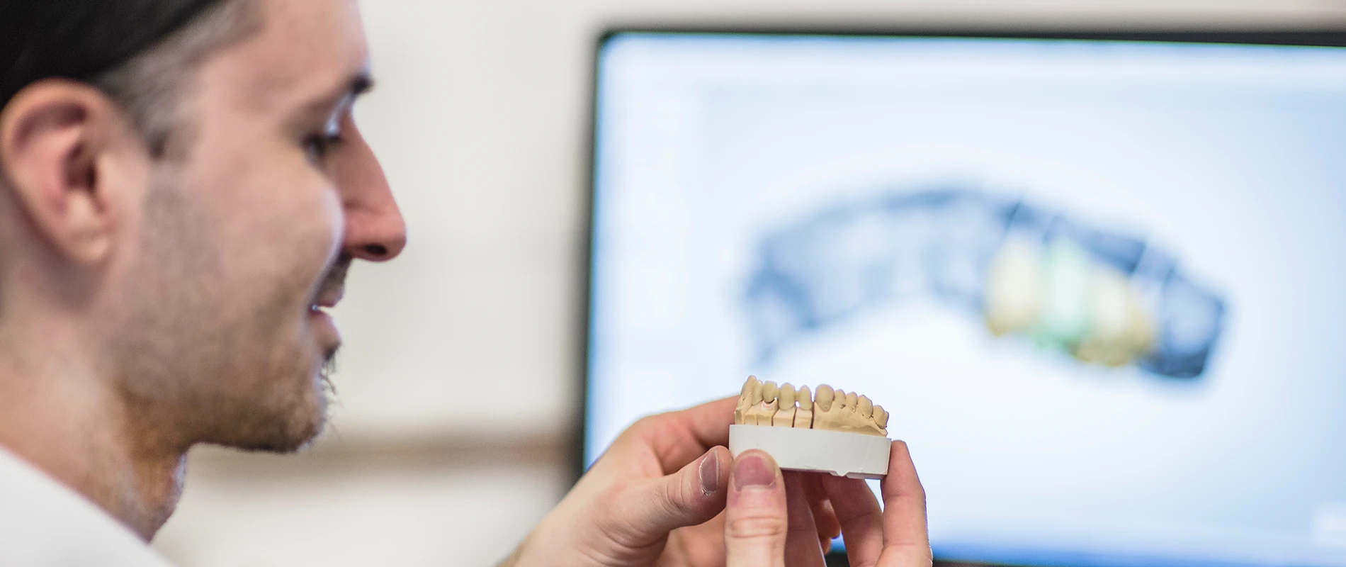 Aufnahme eines Zahntechnikers mit 3D-Zahnmodell in der Hand