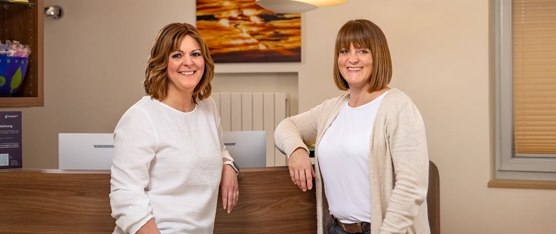 Portraitaufnahme von zwei Empfangsmitarbeiterinnen