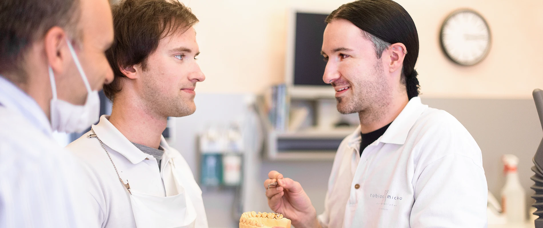 Aufnahme von drei Zahntechnikern im Gespräch untereinander